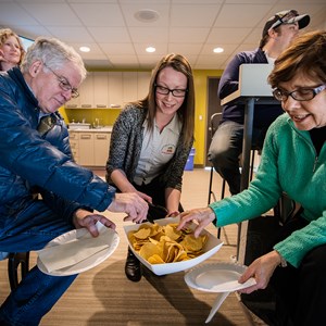 Patrons enjoy snacking on some nachos in a suite